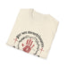 T-shirt beige plié avec une impression représentant une couronne d'épines et une main rouge.