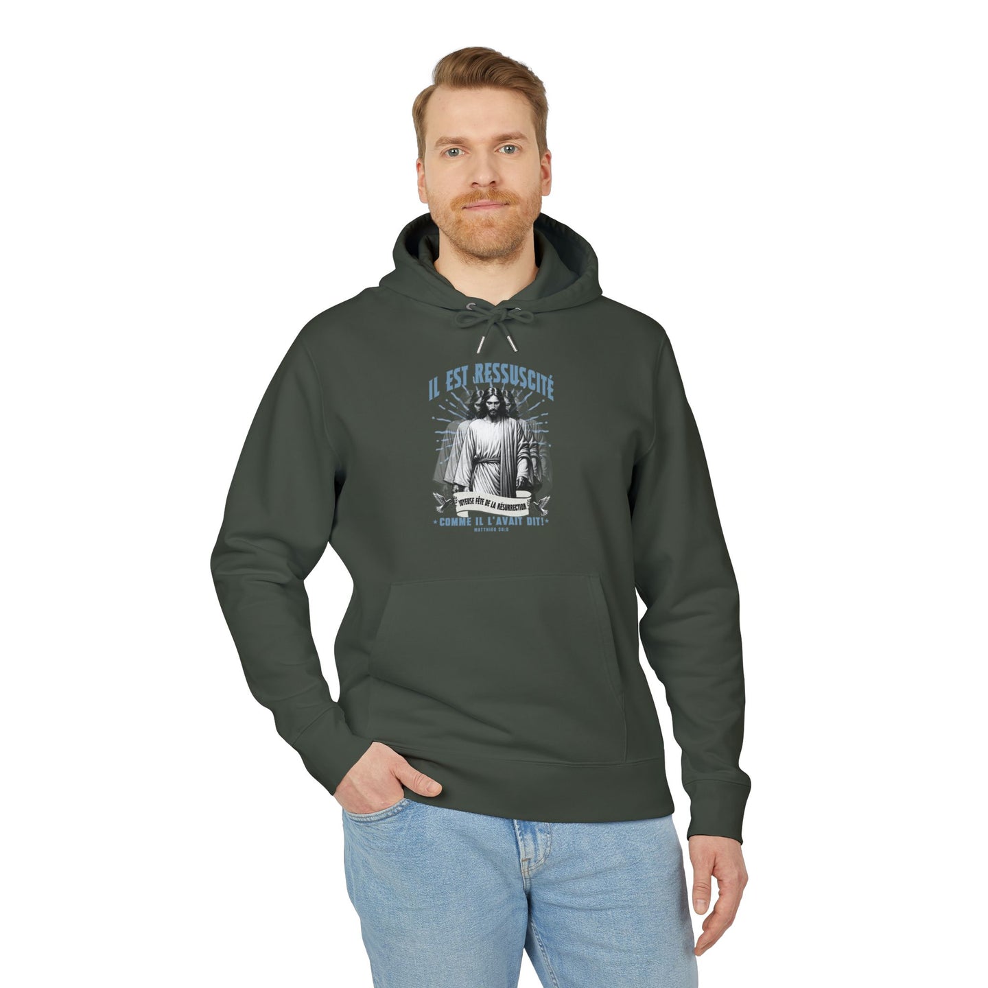 Un homme porte un sweat à capuche vert foncé avec une illustration religieuse sur la poitrine.
