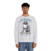 Un homme porte un sweatshirt gris chiné avec une illustration religieuse et le texte Il est ressuscité.