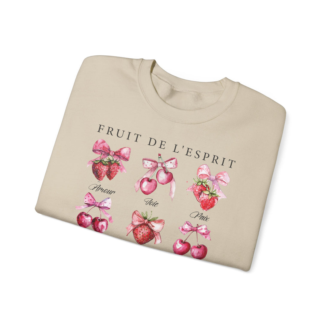 Sweat-shirt beige plié orné d'illustrations de fraises et de cerises avec des nœuds roses.