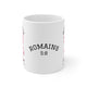 Mug blanc en céramique avec le texte Romains 5:8 et un motif vichy rose.