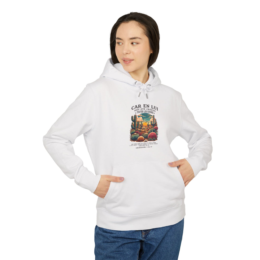 Une femme porte un sweat à capuche blanc avec une illustration de cactus et un texte religieux.