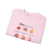 Sweatshirt rose pâle plié avec des illustrations de feuilles et des versets bibliques imprimés.