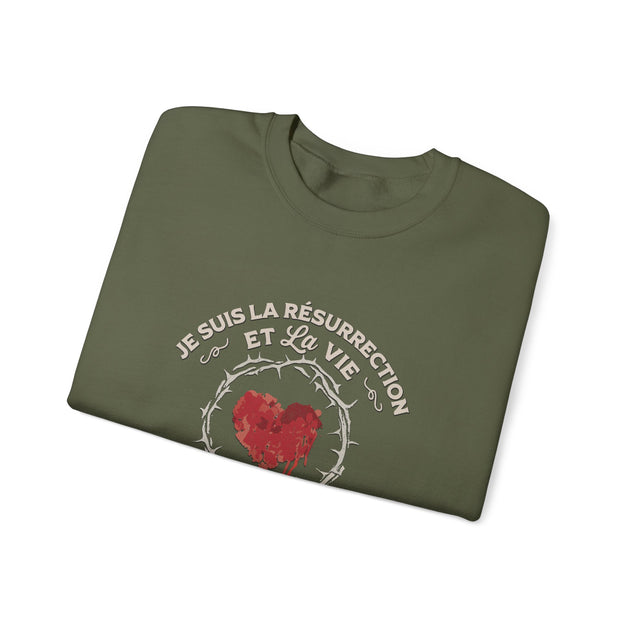 Sweat-shirt vert olive plié avec un motif de cœur couronné d'épines et une inscription religieuse.