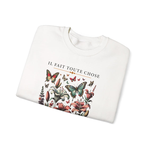 Sweatshirt blanc plié orné d'une illustration de fleurs et de papillons avec le texte français.
