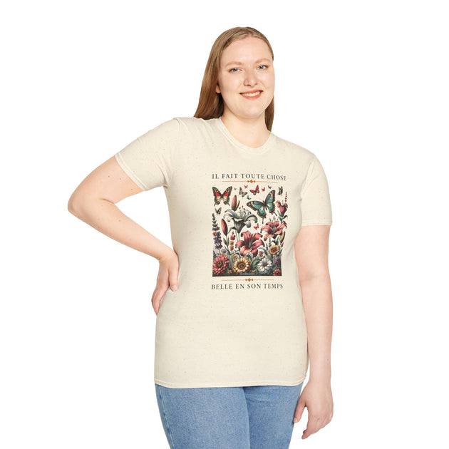 Une femme porte un t-shirt beige chiné orné d'un motif floral et de papillons avec une inscription.