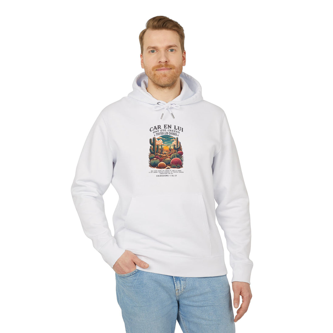 Un homme porte un sweat à capuche blanc en coton avec une illustration de désert et un verset.