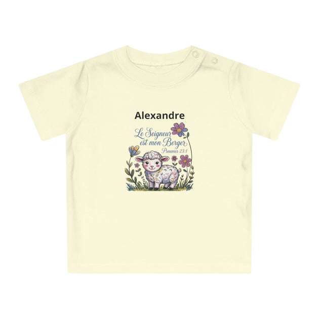 T-shirt pour bébé en coton bio crème avec le prénom Alexandre et un agneau entouré de fleurs.