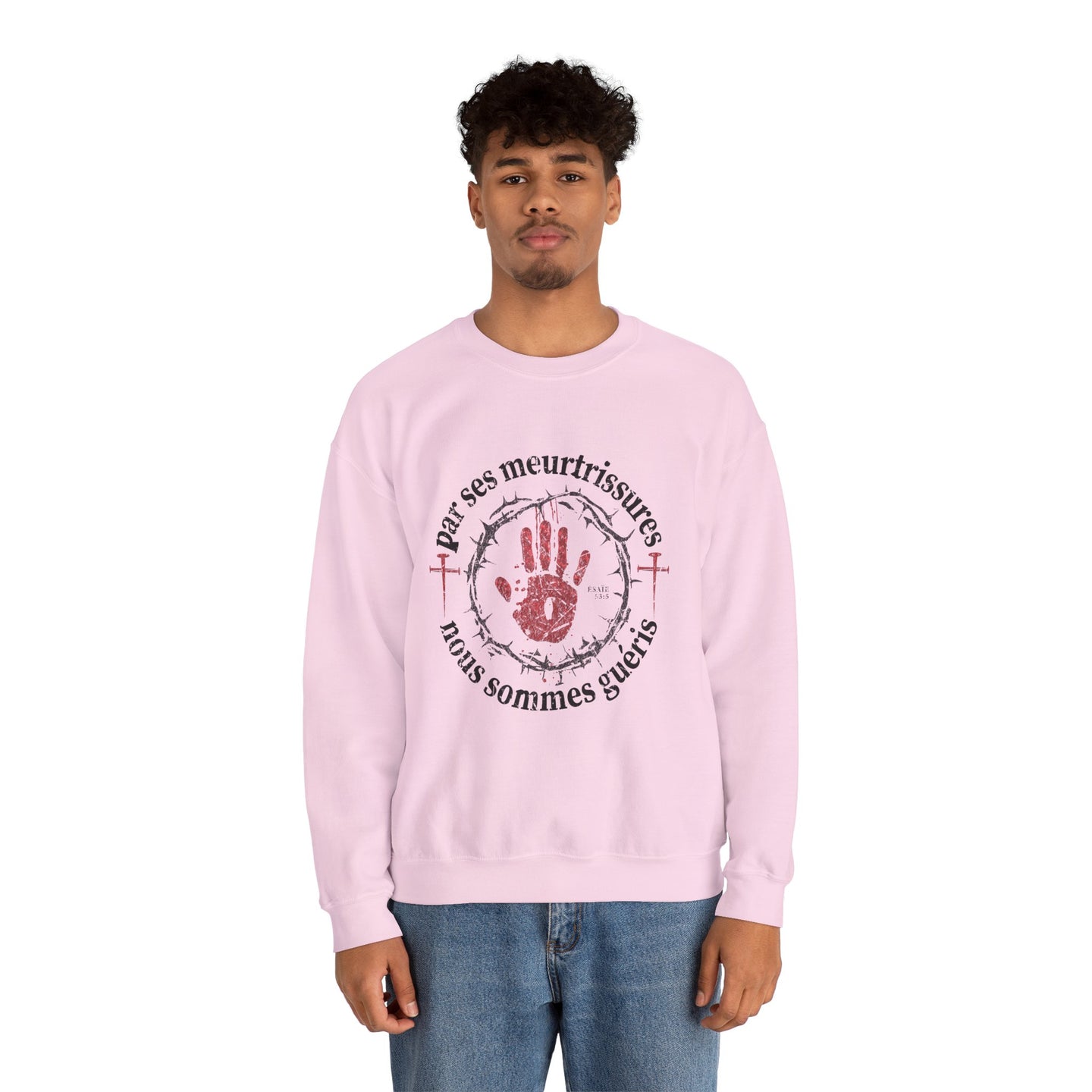 Un homme porte un sweat-shirt rose avec une impression religieuse centrée sur la poitrine.