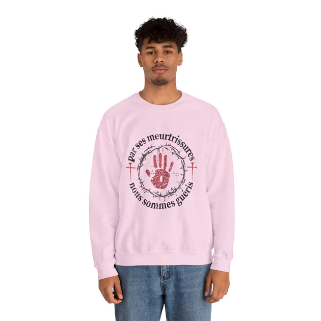 Un homme porte un sweat-shirt rose avec une impression religieuse centrée sur la poitrine.