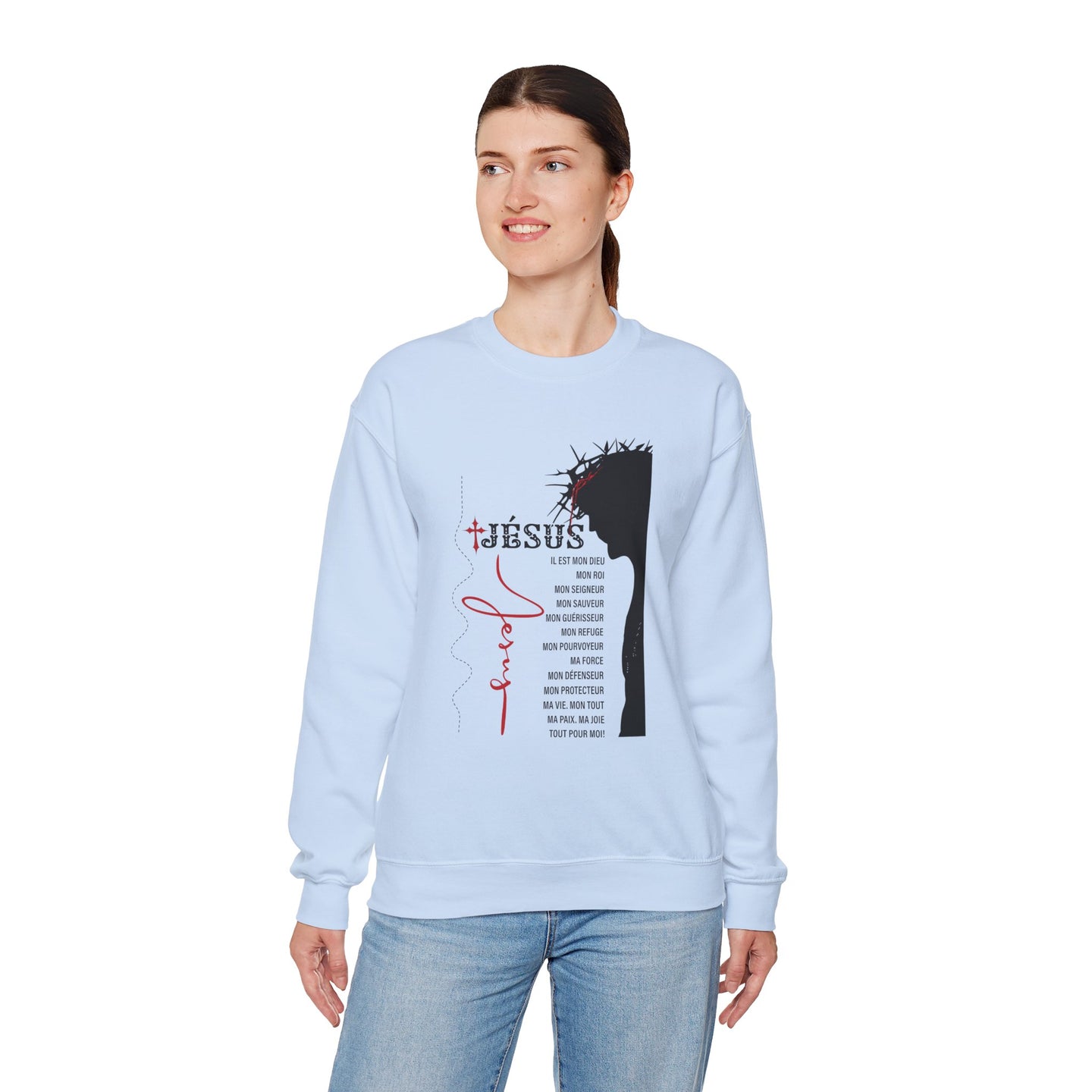 Une femme porte un sweat-shirt bleu clair orné d'une illustration religieuse et de texte en français.