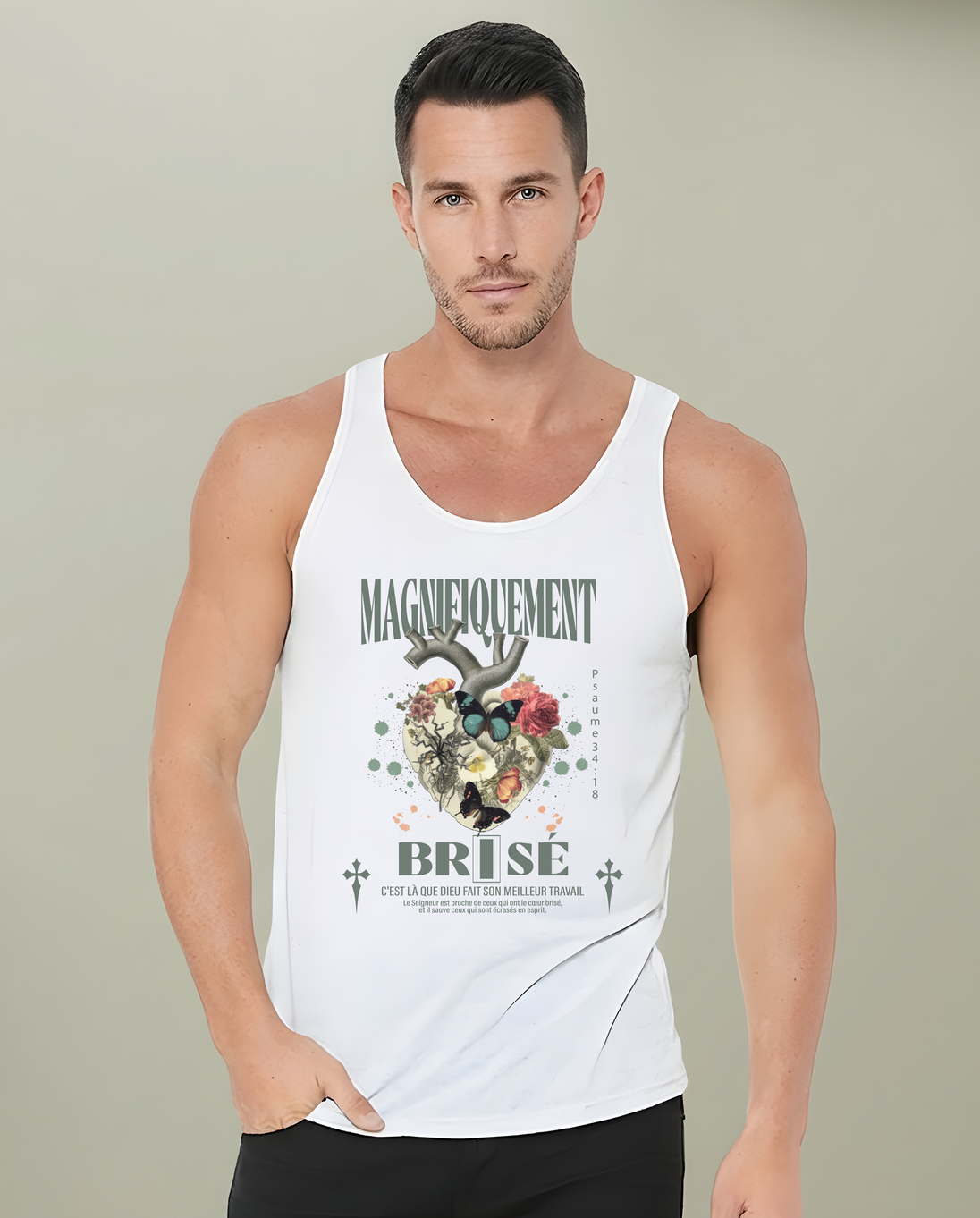 Un homme porte un débardeur blanc avec une illustration de cœur floral et le texte Magnifiquement Brisé.