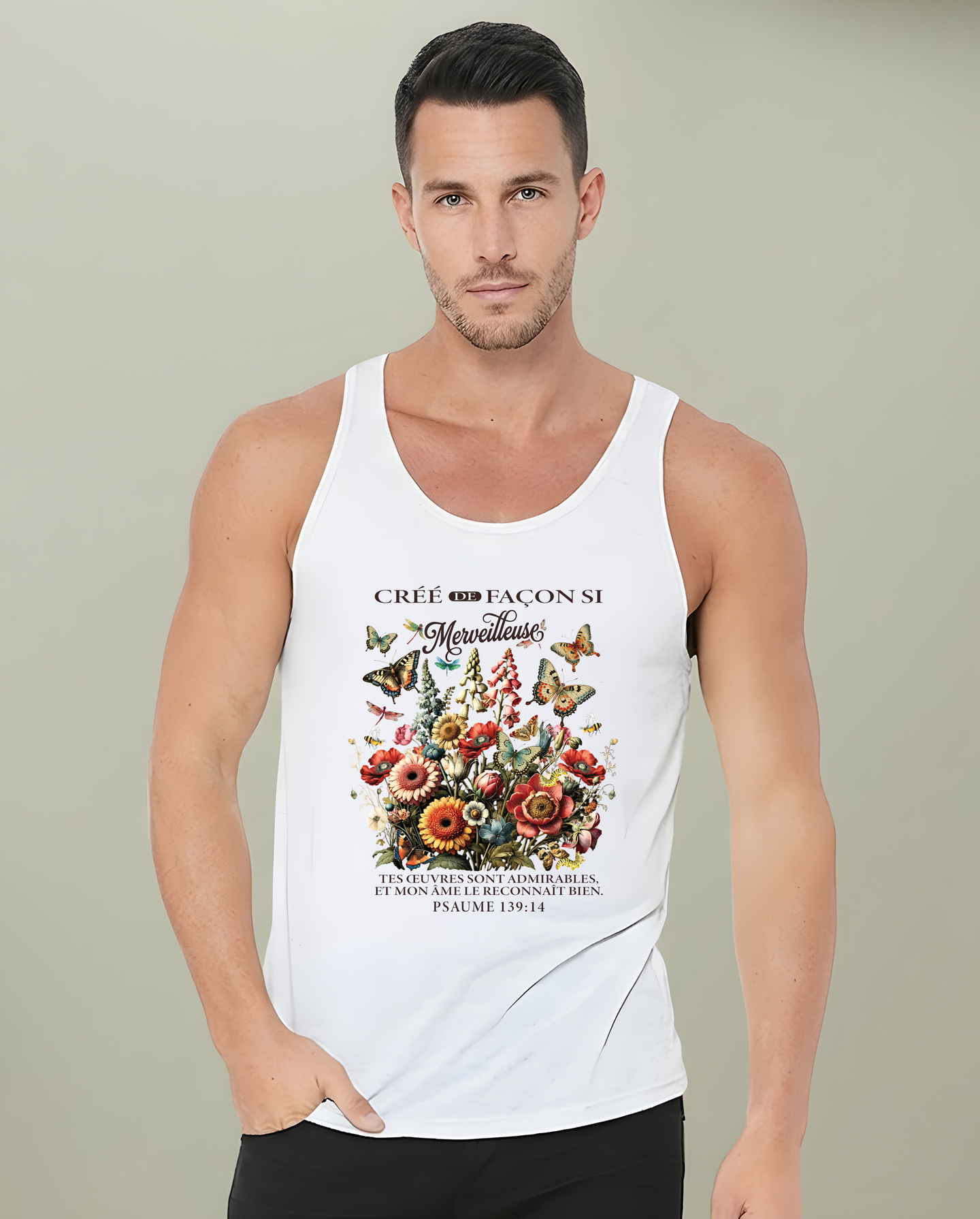 Un homme porte un débardeur blanc orné d'un motif floral vintage et d'un texte en français.