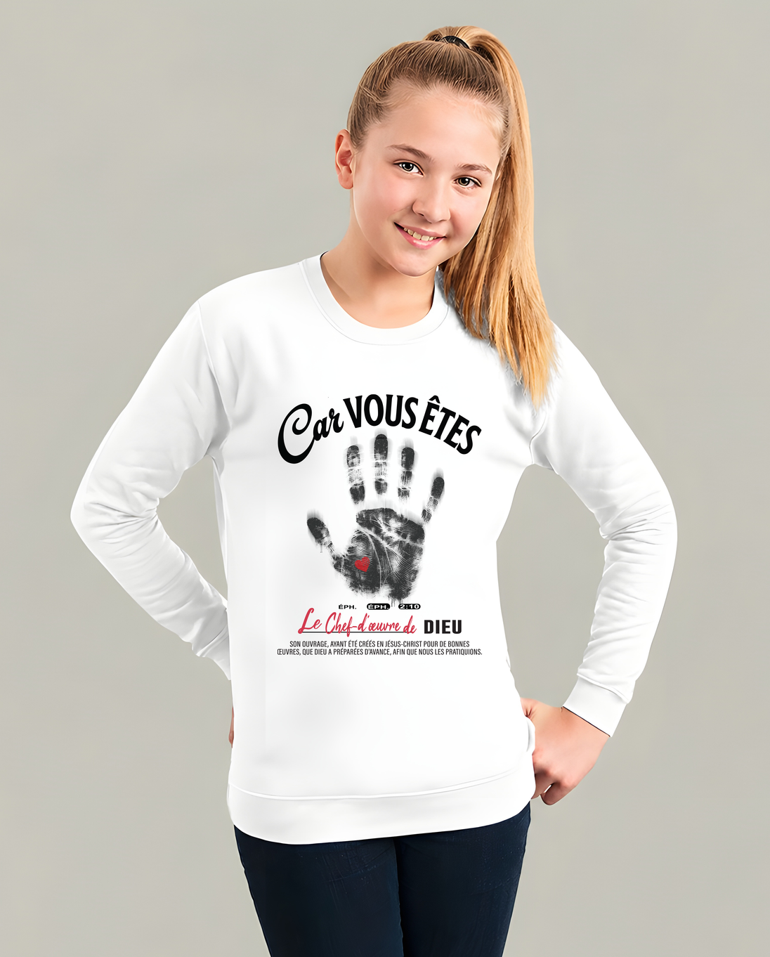 Une jeune fille porte un sweat-shirt blanc avec une empreinte de main et un message religieux.