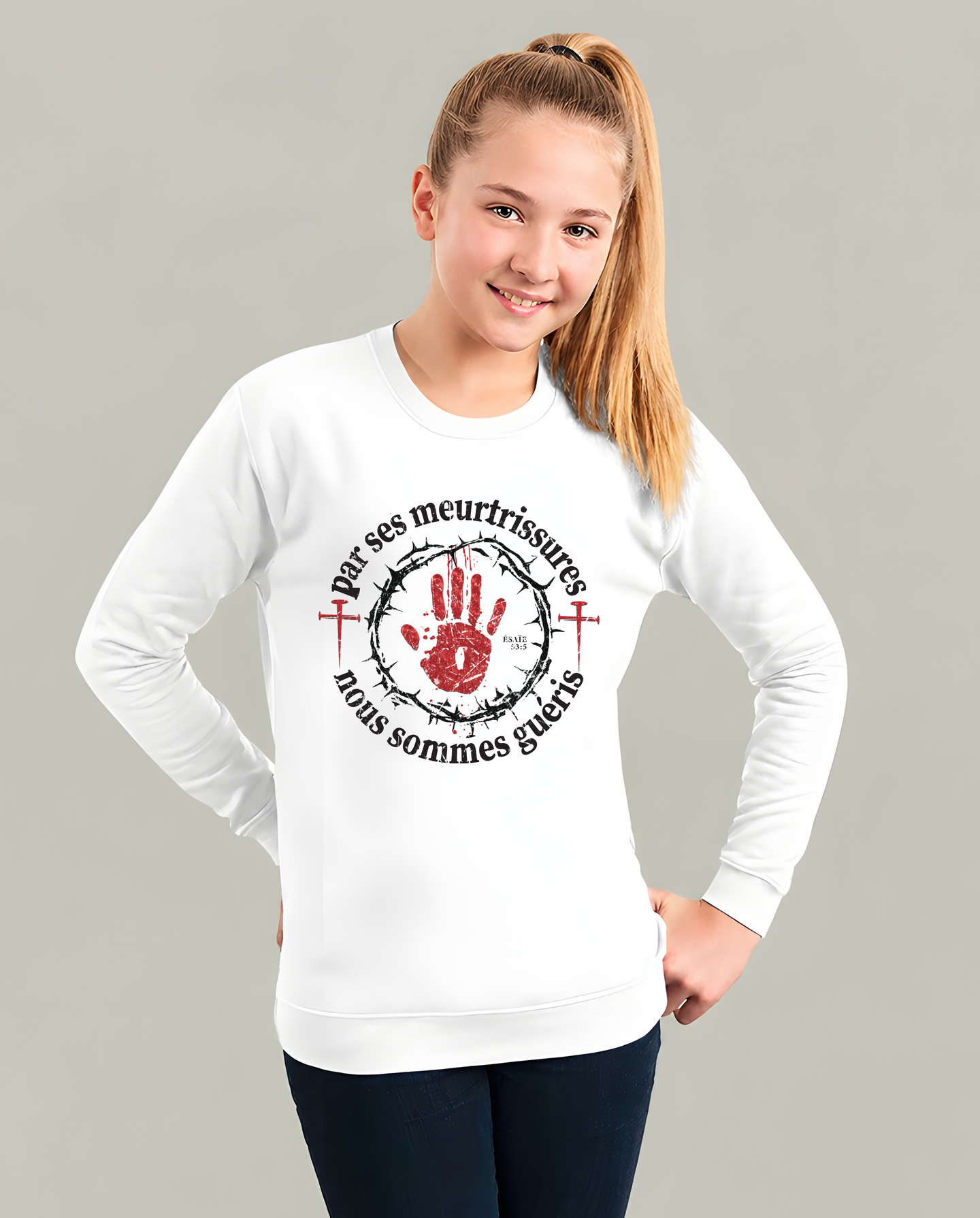 Une jeune fille porte un sweat-shirt blanc avec une impression religieuse et une couronne d'épines.