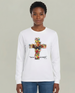 Une femme porte un t-shirt blanc à manches longues orné d'une croix florale et du texte religieux.