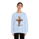 Une femme porte un sweat-shirt blanc orné d'une croix florale et de l'inscription Tout est accompli.
