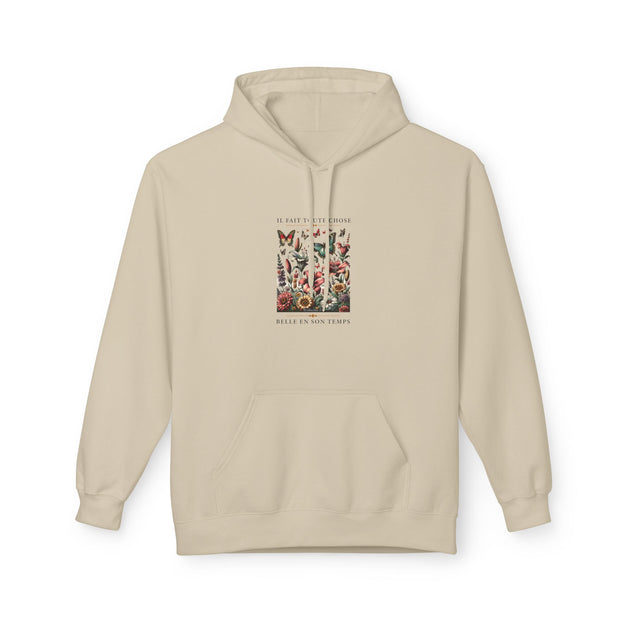 Sweat à capuche beige avec une illustration florale et le texte Il fait toute chose belle.