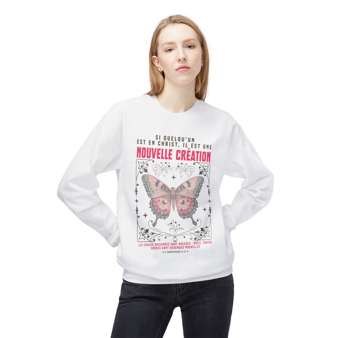 Une femme porte un sweat-shirt blanc avec un motif de papillon et un texte religieux en français.
