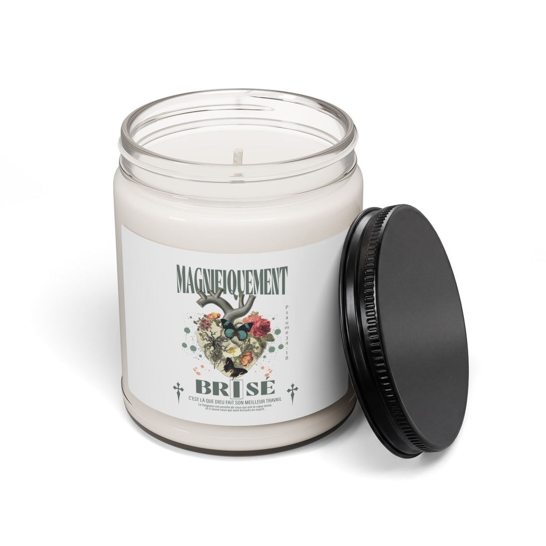 Une bougie en cire blanche dans un pot en verre avec un couvercle noir et une étiquette illustrée.