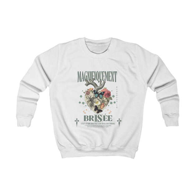 Sweatshirt blanc pour enfant avec une illustration botanique et un texte religieux sur le devant.