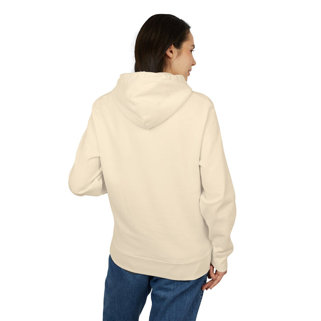 Une femme porte un sweat à capuche beige uni vu de dos, associé à un jean bleu.