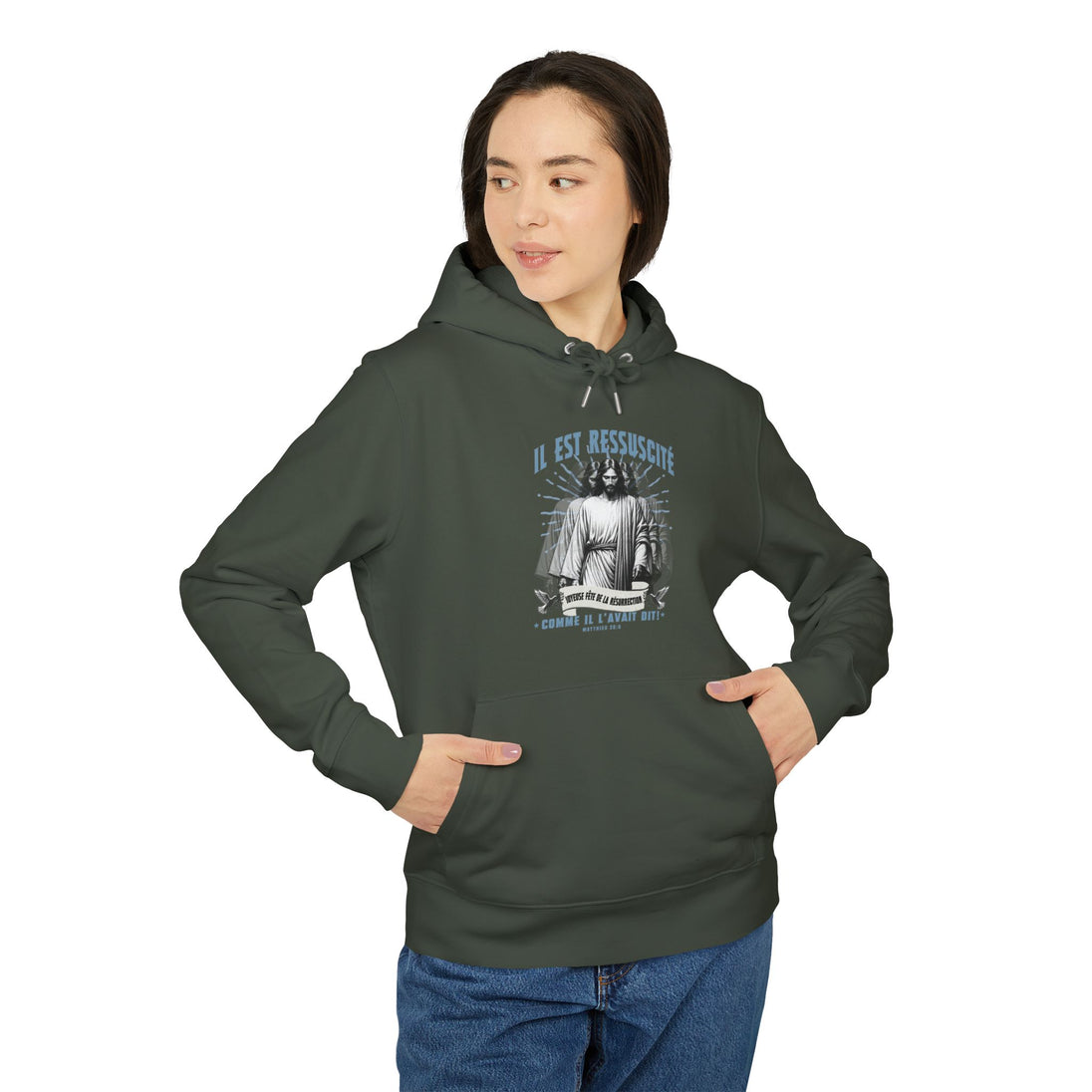 Une femme porte un sweat à capuche vert foncé avec une illustration religieuse sur la poitrine.