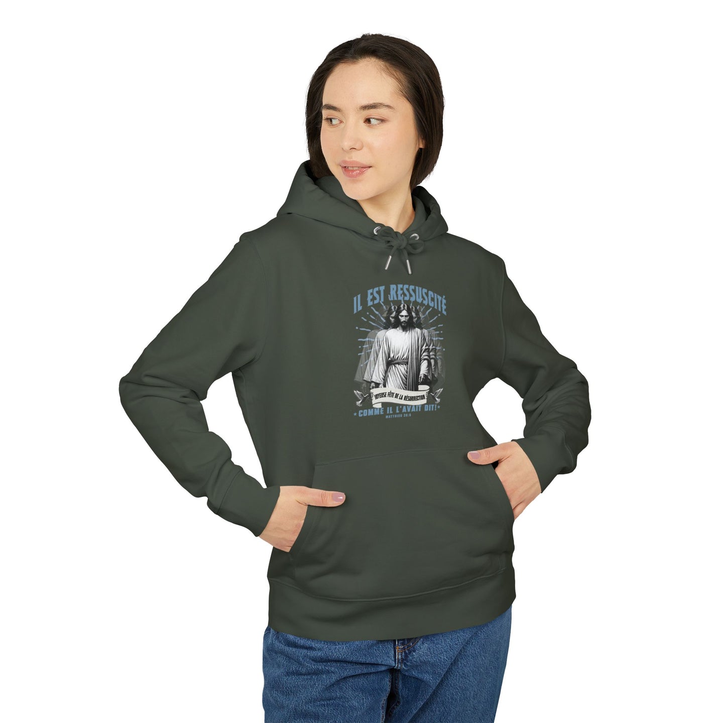 Une femme porte un sweat à capuche vert foncé avec une illustration religieuse sur la poitrine.