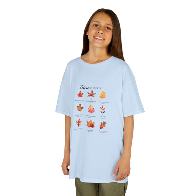 Une jeune fille porte un t-shirt bleu clair orné d'un motif de feuilles et de textes religieux.