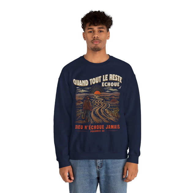 Un homme porte un sweatshirt bleu marine avec une illustration de paysage et un message religieux.