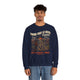 Un homme porte un sweatshirt bleu marine avec une illustration de paysage et un message religieux.