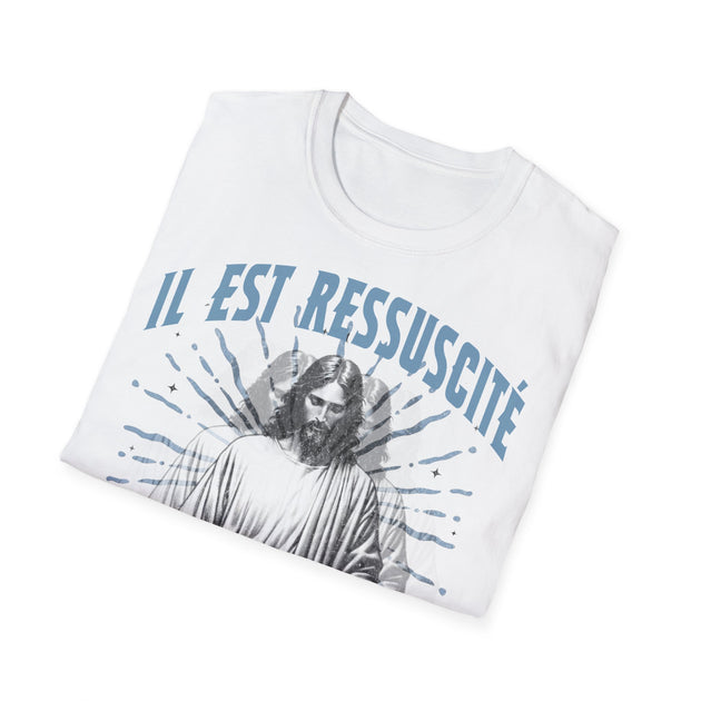 T-shirt blanc plié avec l'inscription Il est ressuscité et une illustration de Jésus.