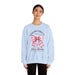 Une femme porte un sweat-shirt bleu clair avec un motif de nœud rose et une croix chrétienne.