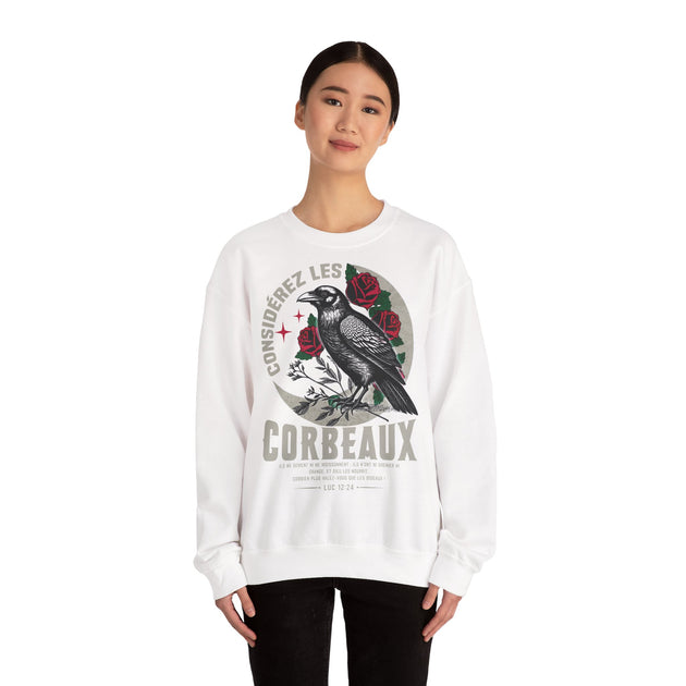 Une femme porte un sweatshirt blanc orné d'un corbeau, de roses et d'un verset biblique.