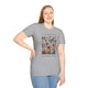 Une femme porte un t-shirt gris orné d'un motif floral et de papillons avec une inscription.