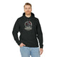 Un homme porte un sweat à capuche noir avec une illustration de corbeau et un texte biblique.