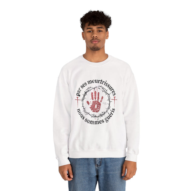 Un homme porte un sweat-shirt blanc avec une impression religieuse centrée sur la poitrine.