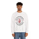 Un homme porte un sweat-shirt blanc avec une impression religieuse centrée sur la poitrine.