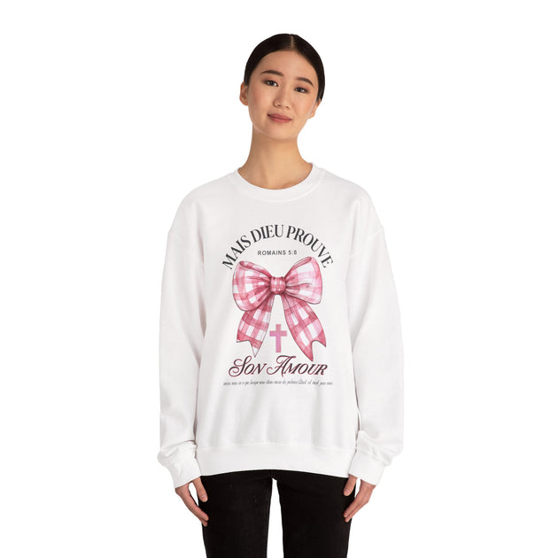 Une femme porte un sweat-shirt blanc avec un motif de nœud rose et un message chrétien.