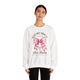 Une femme porte un sweat-shirt blanc avec un motif de nœud rose et un message chrétien.