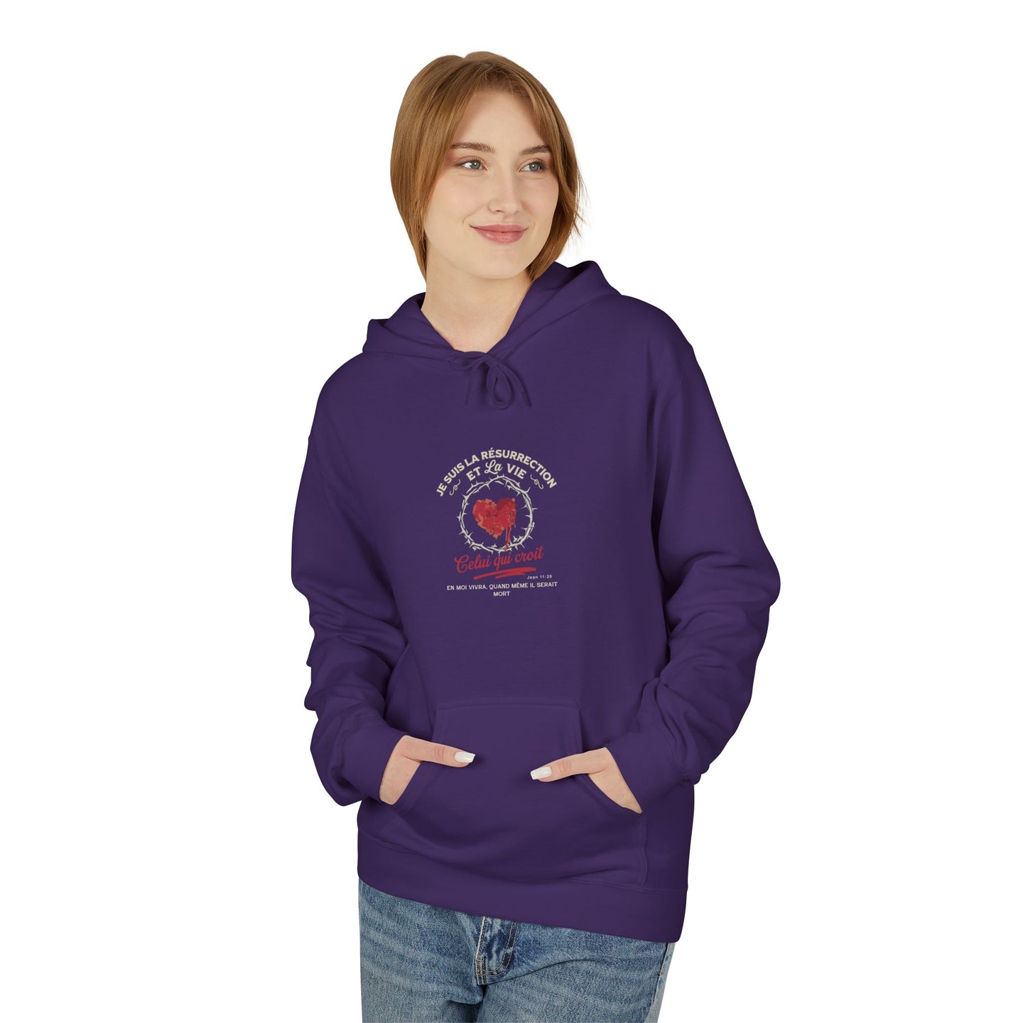 Une femme porte un sweat à capuche violet avec un motif religieux centré sur la poitrine.