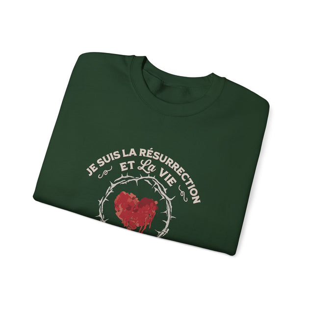 Sweat-shirt vert foncé plié avec l'inscription Je suis la résurrection et la vie et un cœur épineux.