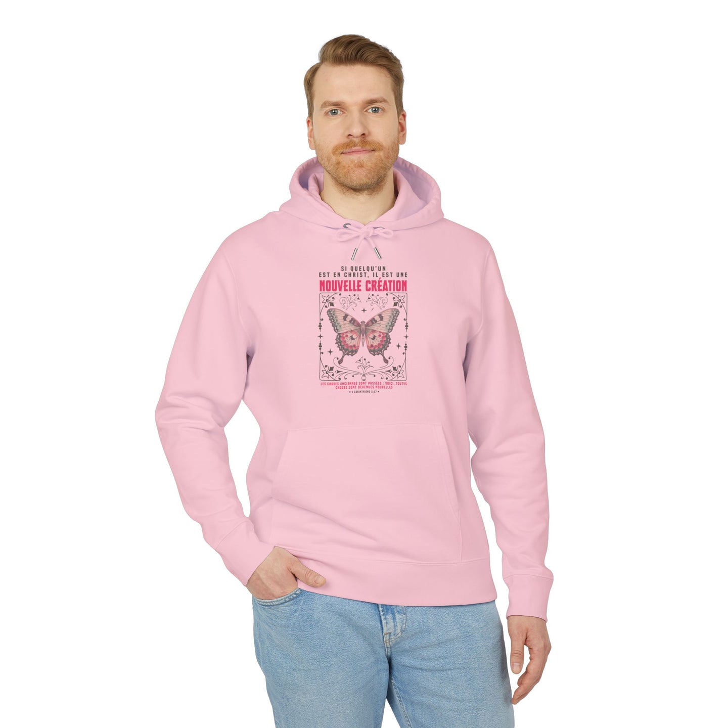Un homme porte un sweat à capuche rose avec un motif de papillon et un texte religieux.