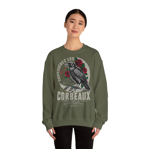 Une femme porte un sweatshirt vert olive orné d'un corbeau, de roses et d'un verset biblique.