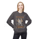 Une femme porte un sweatshirt gris foncé avec une illustration de pains et de poissons.