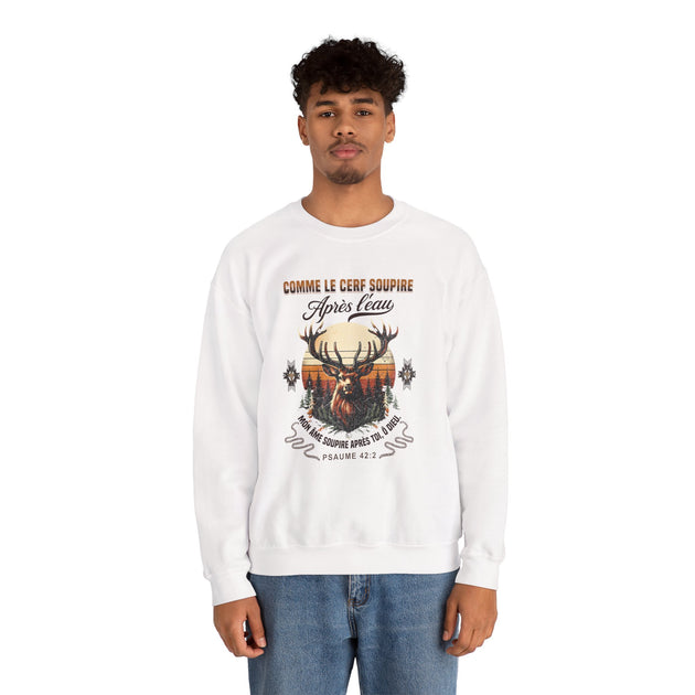 Un homme porte un sweat-shirt blanc avec une illustration de cerf et un texte religieux en français.