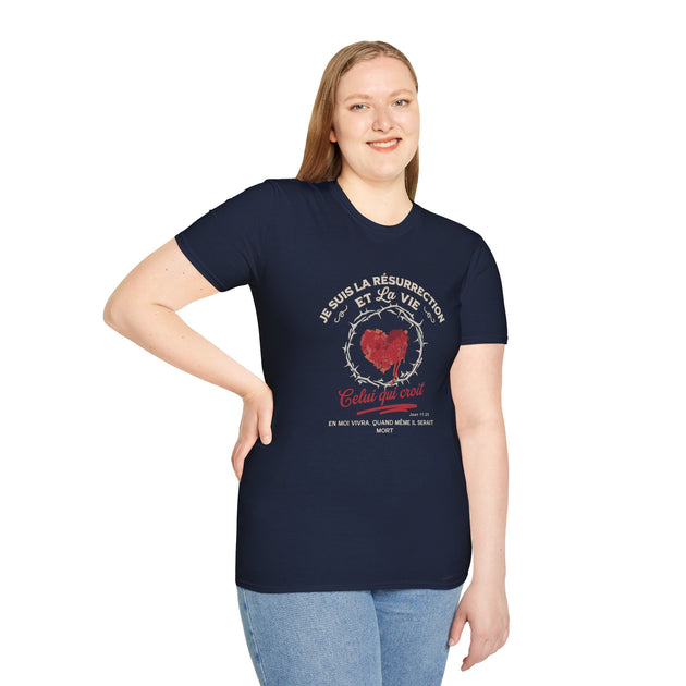 Une femme porte un t-shirt bleu marine avec un motif religieux représentant un cœur et des textes.