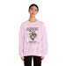 Une femme porte un sweat-shirt rose pâle orné d'un motif de cœur floral et du texte Magnifiquement Brisée.
