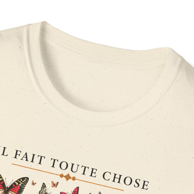 T-shirt beige chiné avec l'inscription Il fait toute chose et des motifs de papillons.