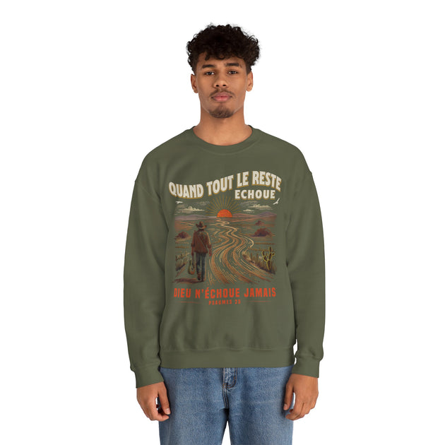 Un homme porte un sweatshirt vert olive avec une illustration de cow-boy et un message religieux.